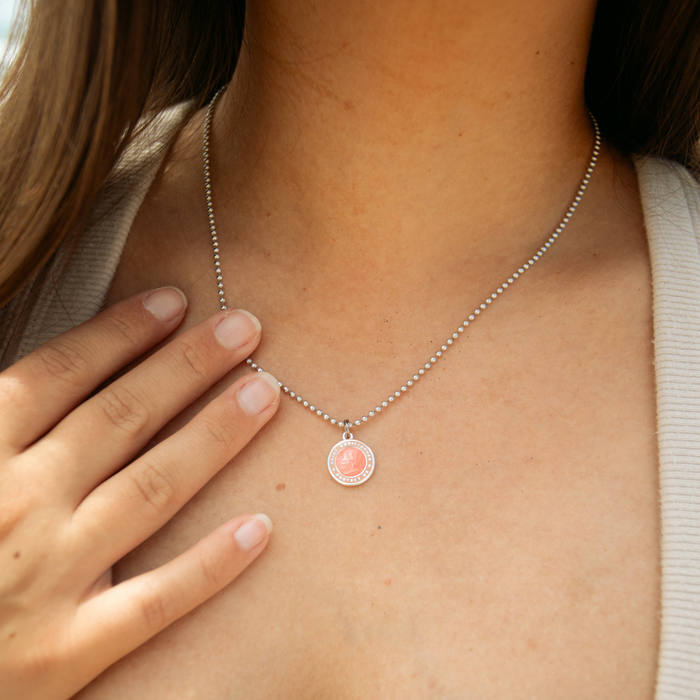 small melon blush st. christopher on model neck
