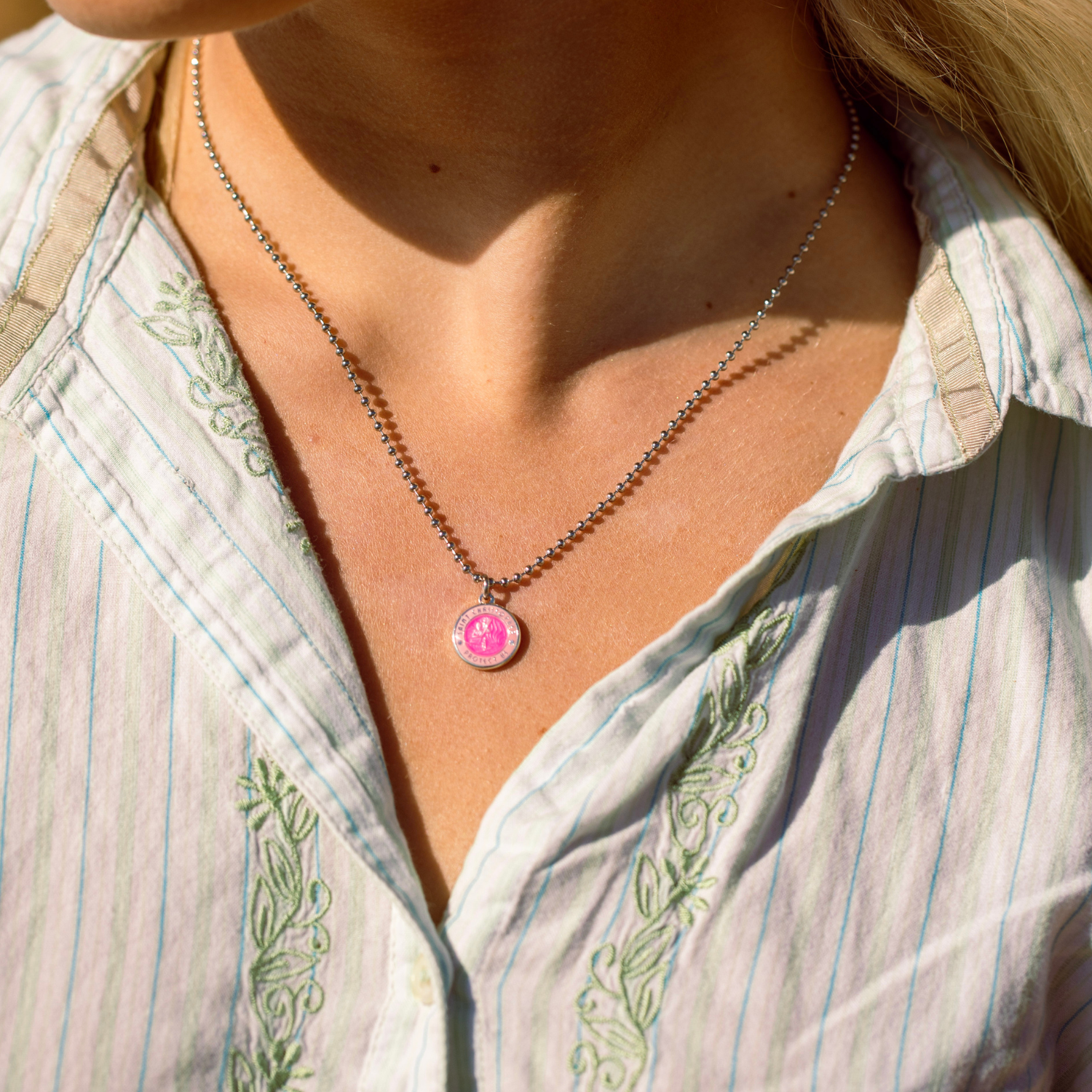 small fuchsia pink st. christopher on model neck 