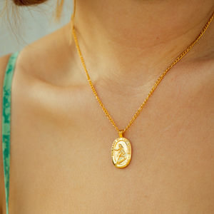 gold lady of the waves necklace close up 
